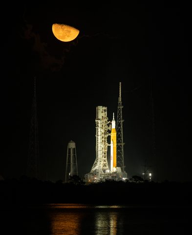 Artemis I SLS on Pad 39B under a crescent moon