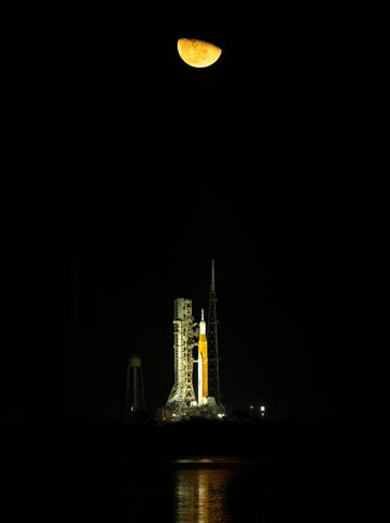 Artemis I SLS night pad reflected in the water